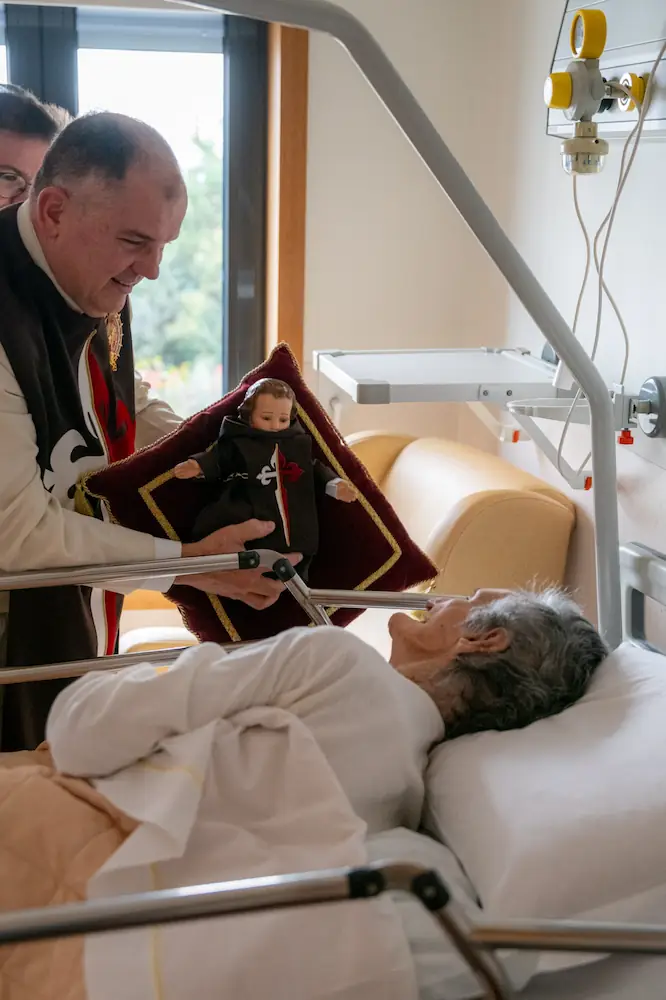 Missionary of the Heralds of the Gospel visiting a resident of a care home with the Child Jesus