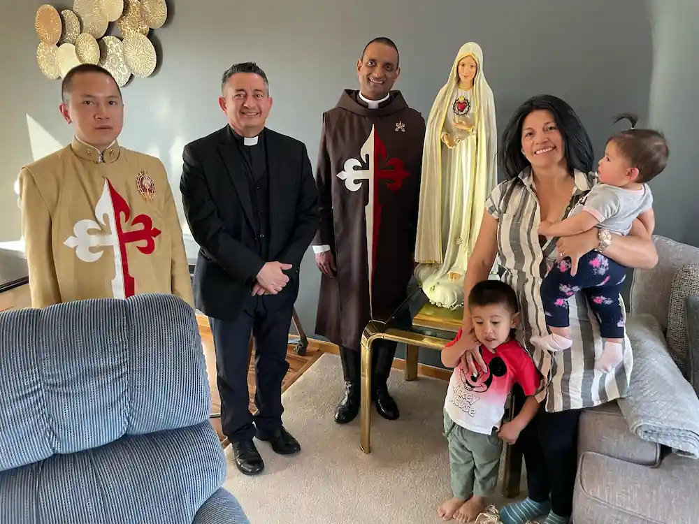Priest and Missionary Brothers of the Heralds of the Gospel visiting a home with the Pilgrim Statue.