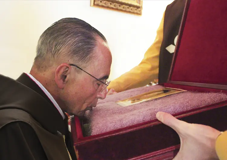 Msgr. João kisses a shawl that belonged to Dona Lucilia