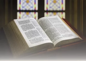 Open Bible on a wooden table symbolizing Sacred Scripture and divine wisdom.