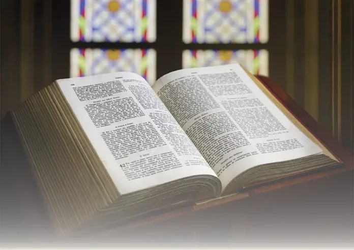 Open Bible on a wooden table symbolizing Sacred Scripture and divine wisdom.
